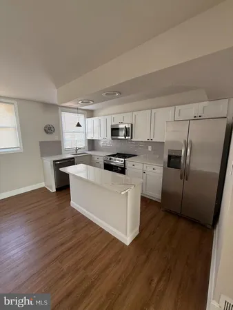 a kitchen with a refrigerator a sink a stove a microwave and cabinets