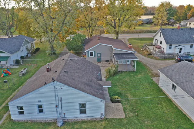 a aerial view of a house next to a big yard and large trees