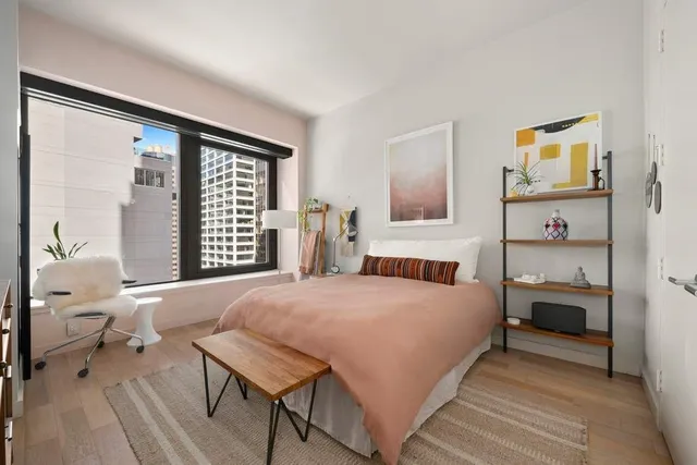 a bedroom with a bed and a large window