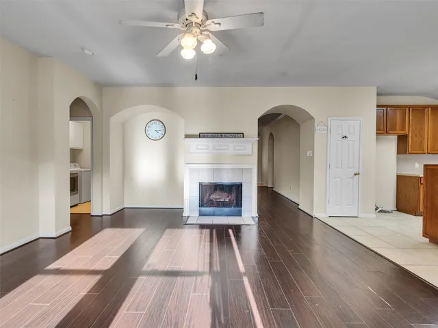 a view of an empty room with a fireplace and wooden floor