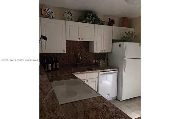 a view of a kitchen with sink and cabinets