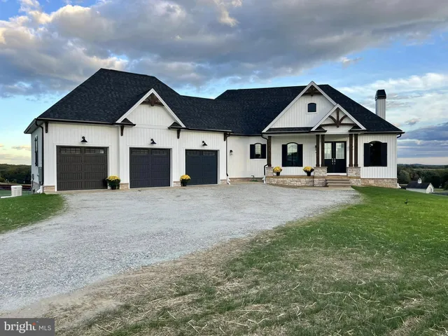 a view of a white house with a big yard and large trees