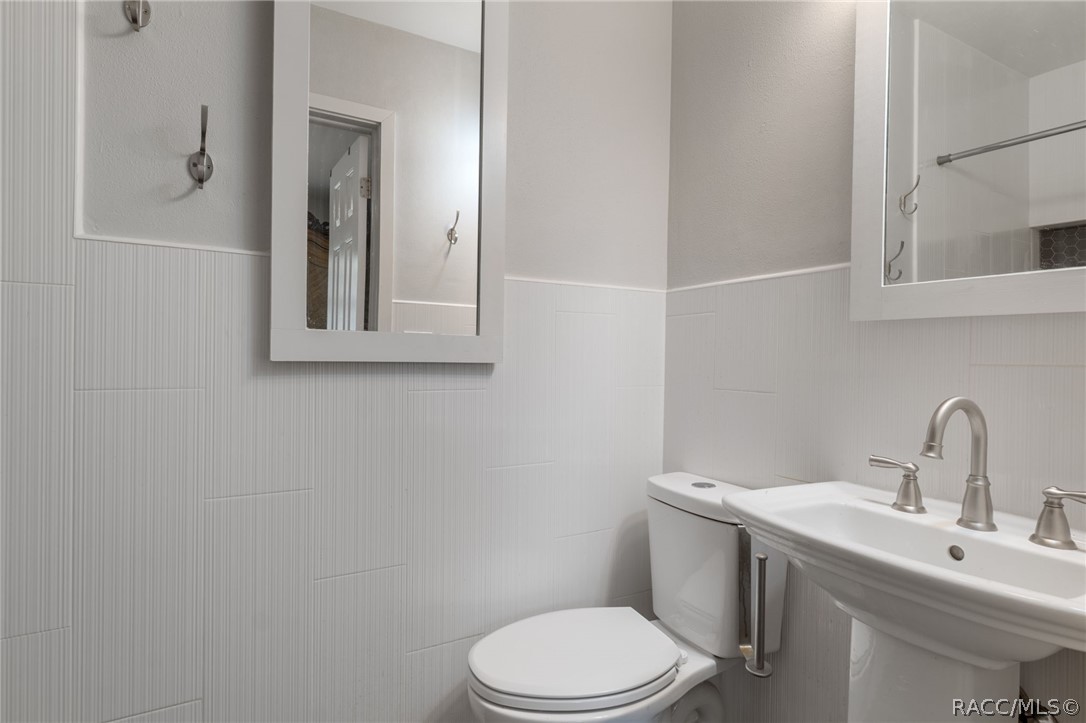 1140 South Highlands Avenue Inverness, FL 34452 - Photo 24 of 54 a white toilet sitting next to a bathroom sink