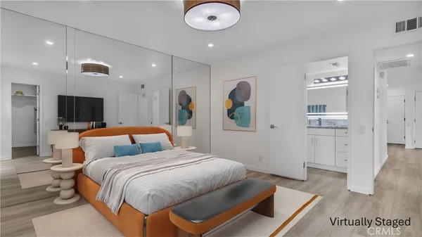 a spacious bedroom with a bed and a television