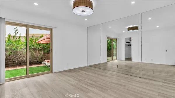 a view of an empty room with glass door and balcony