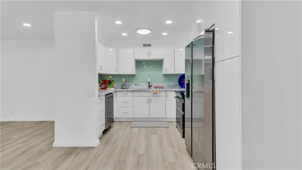 a kitchen with white cabinets and white appliances