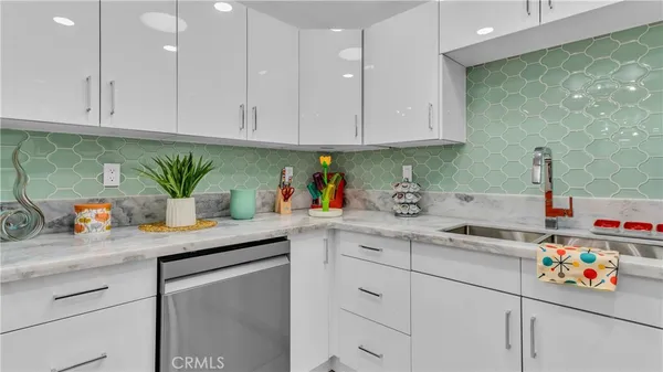 a kitchen with stainless steel appliances granite countertop white cabinets a sink and dishwasher