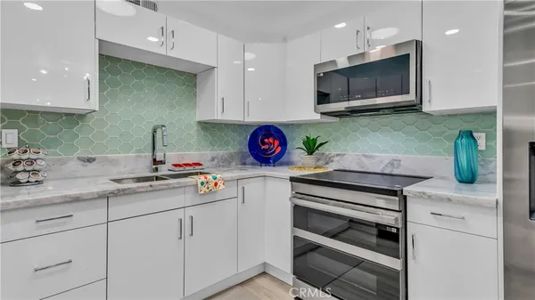 a kitchen with stainless steel appliances granite countertop a sink and a microwave
