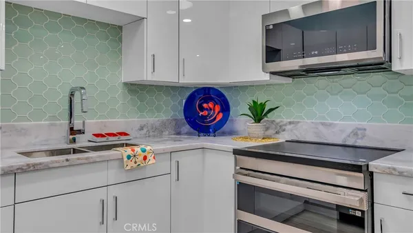 a kitchen with stainless steel appliances granite countertop a sink and a microwave