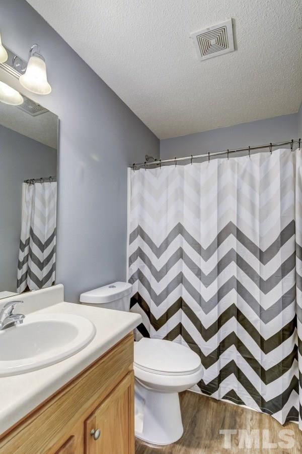 3323 Marcony Way Raleigh, NC 27610 - Photo 12 of 14 a bathroom with a sink a toilet and a mirror