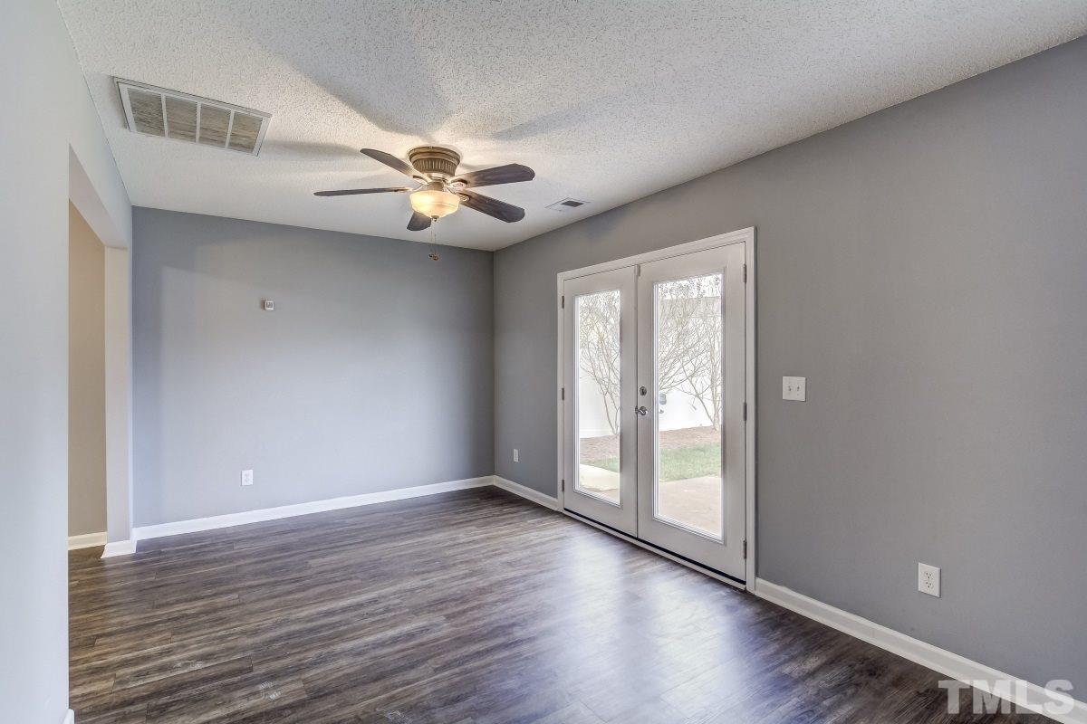 3323 Marcony Way Raleigh, NC 27610 - Photo 4 of 14 an empty room with wooden floor chandelier fan and windows