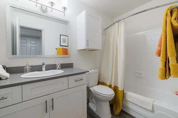 a bathroom with a granite countertop sink toilet and shower