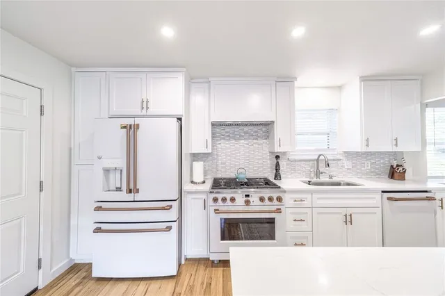 a kitchen with stainless steel appliances a stove a sink and cabinets