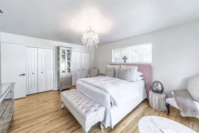 a spacious bedroom with a bed and a chandelier