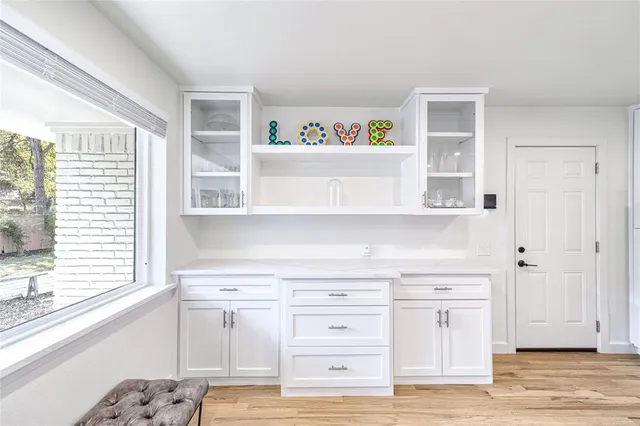 a view of cabinets a wooden floor and a window in a room