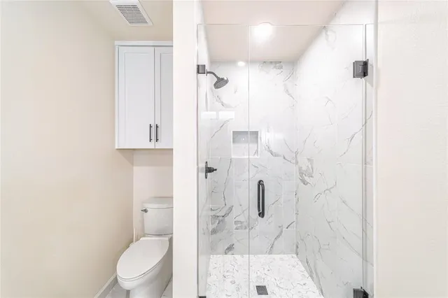 a bathroom with a toilet and shower