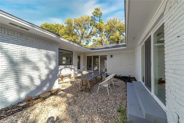 a backyard of a house with table and chairs