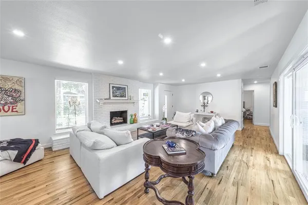 a living room with fireplace furniture flat screen tv and windows