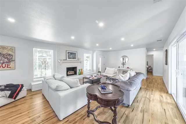 a living room with fireplace furniture flat screen tv and windows