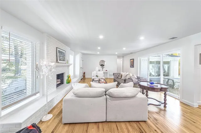 a living room with fireplace furniture and a large window