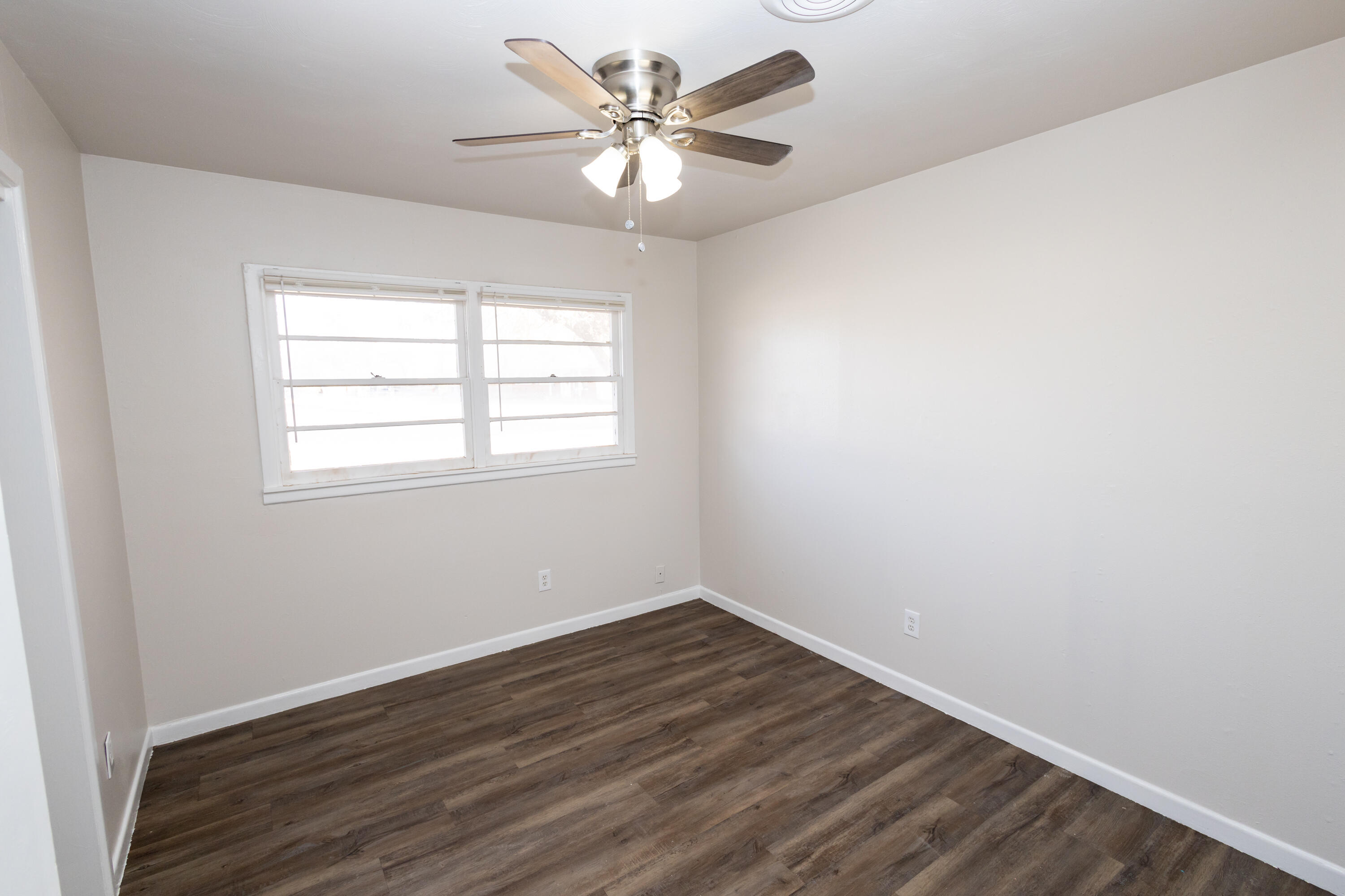 606 Bangor Avenue Lubbock, TX 79416 - Photo 16 of 26 an empty room with wooden floor and windows