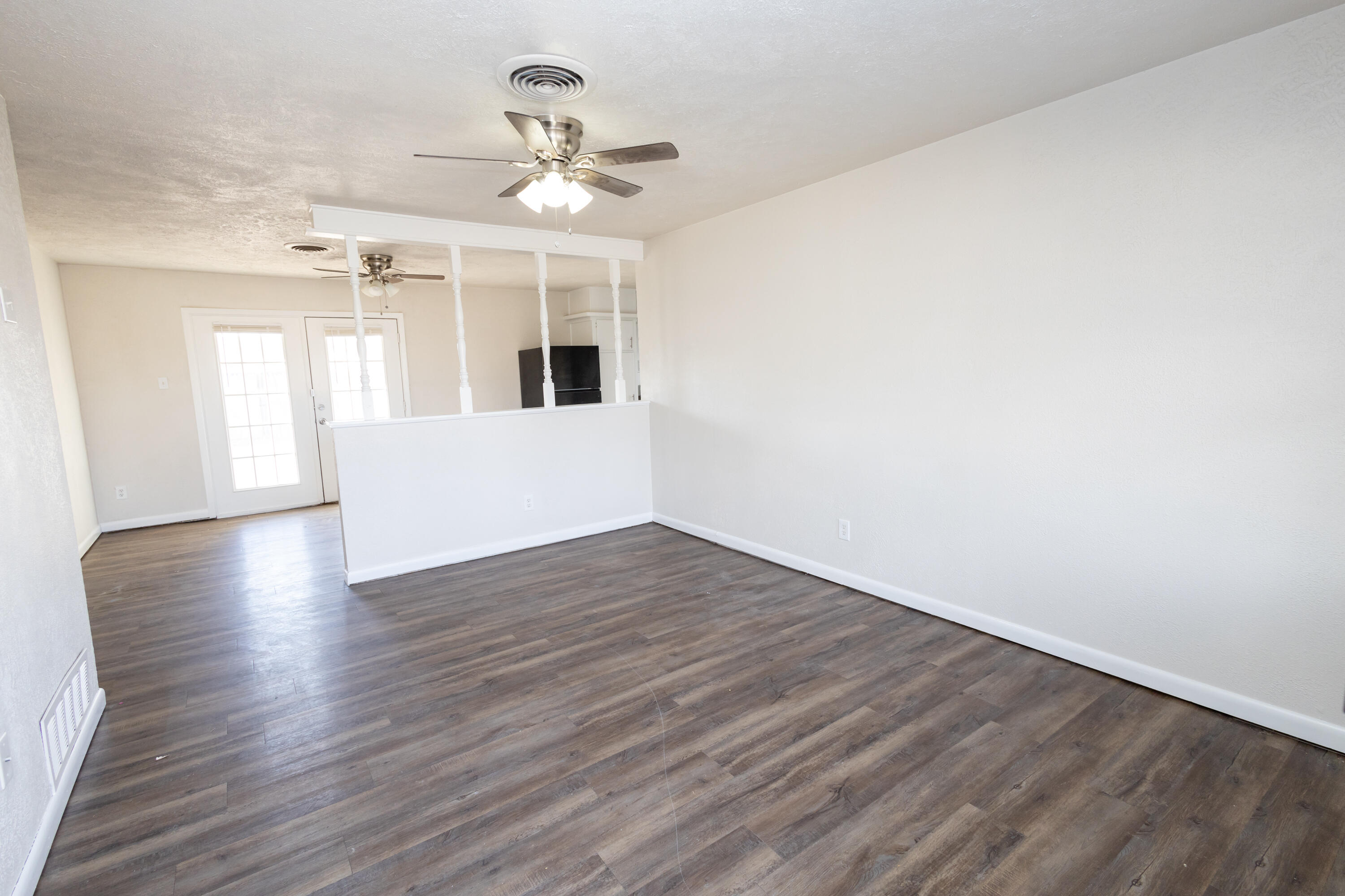 606 Bangor Avenue Lubbock, TX 79416 - Photo 6 of 26 a view of an empty room with wooden floor and a window
