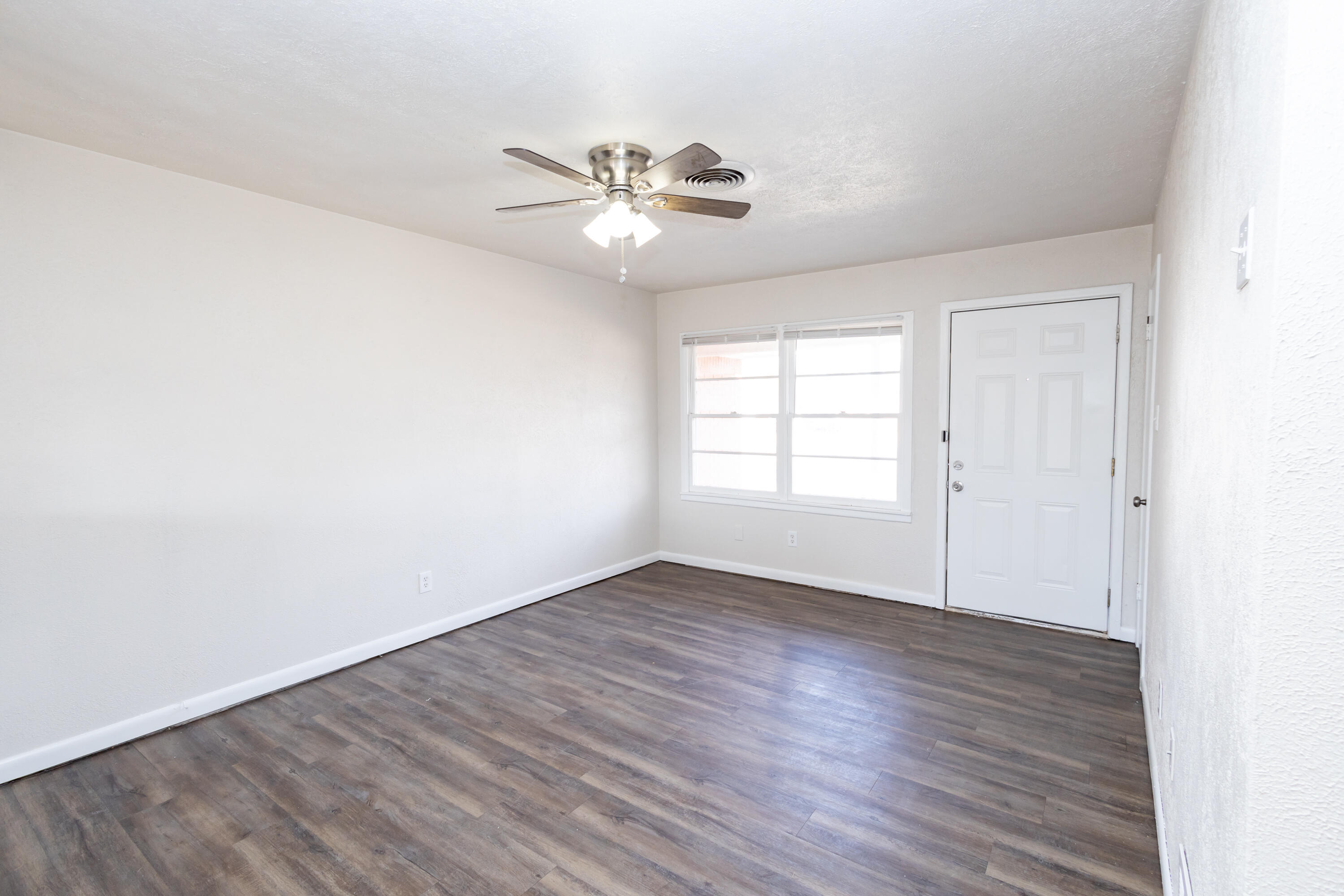 606 Bangor Avenue Lubbock, TX 79416 - Photo 7 of 26 a view of an empty room with wooden floor and a window
