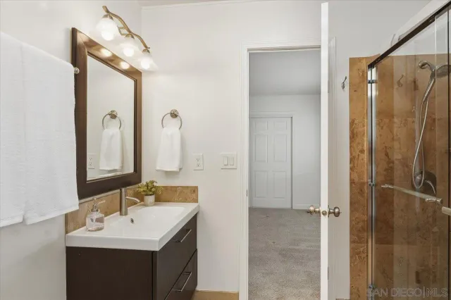 a bathroom with a double vanity sink mirror and shower