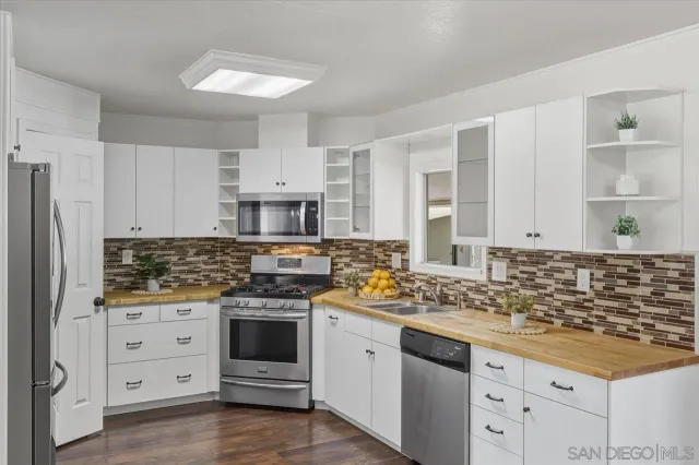 a kitchen with cabinets appliances a sink and a counter top space
