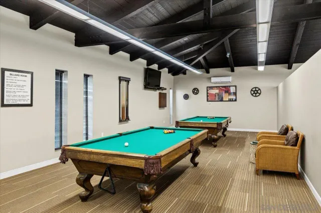 a room with pool table and wooden floor