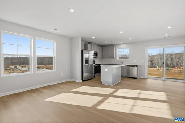 a large kitchen with stainless steel appliances kitchen island a large counter a sink and a large window