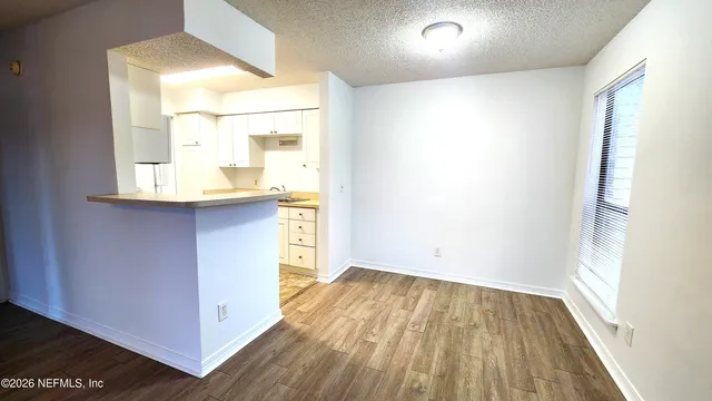 a view of hallway with wooden floor and cabinet