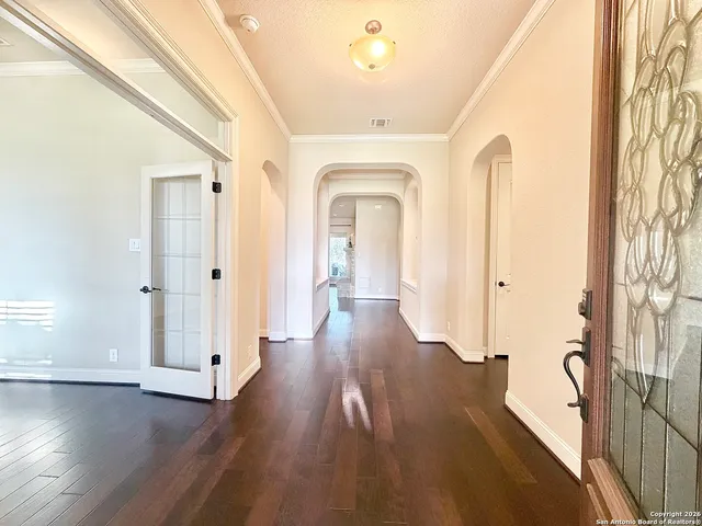 a view of a hallway with wooden floor and stairs