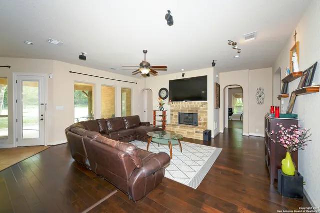 a living room with furniture kitchen view and a large window