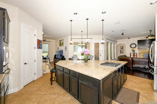 a room with stainless steel appliances kitchen island granite countertop furniture and a dining table