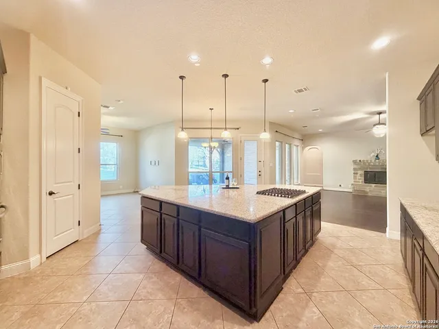 a large kitchen with a large counter top a sink a stove and refrigerator