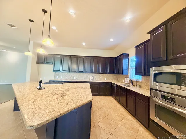 a kitchen with a sink a microwave a stove and refrigerator
