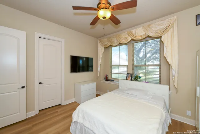a spacious bedroom with a large bed a chandelier and a large window