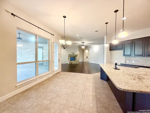 a large kitchen with kitchen island a counter top a sink and a wooden floor