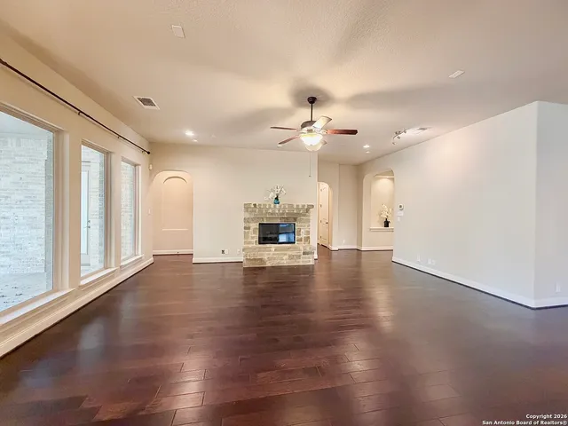 a view of a livingroom with wooden floor and a ceiling fan
