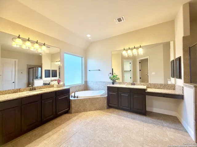 a large bathroom with a large tub and sink