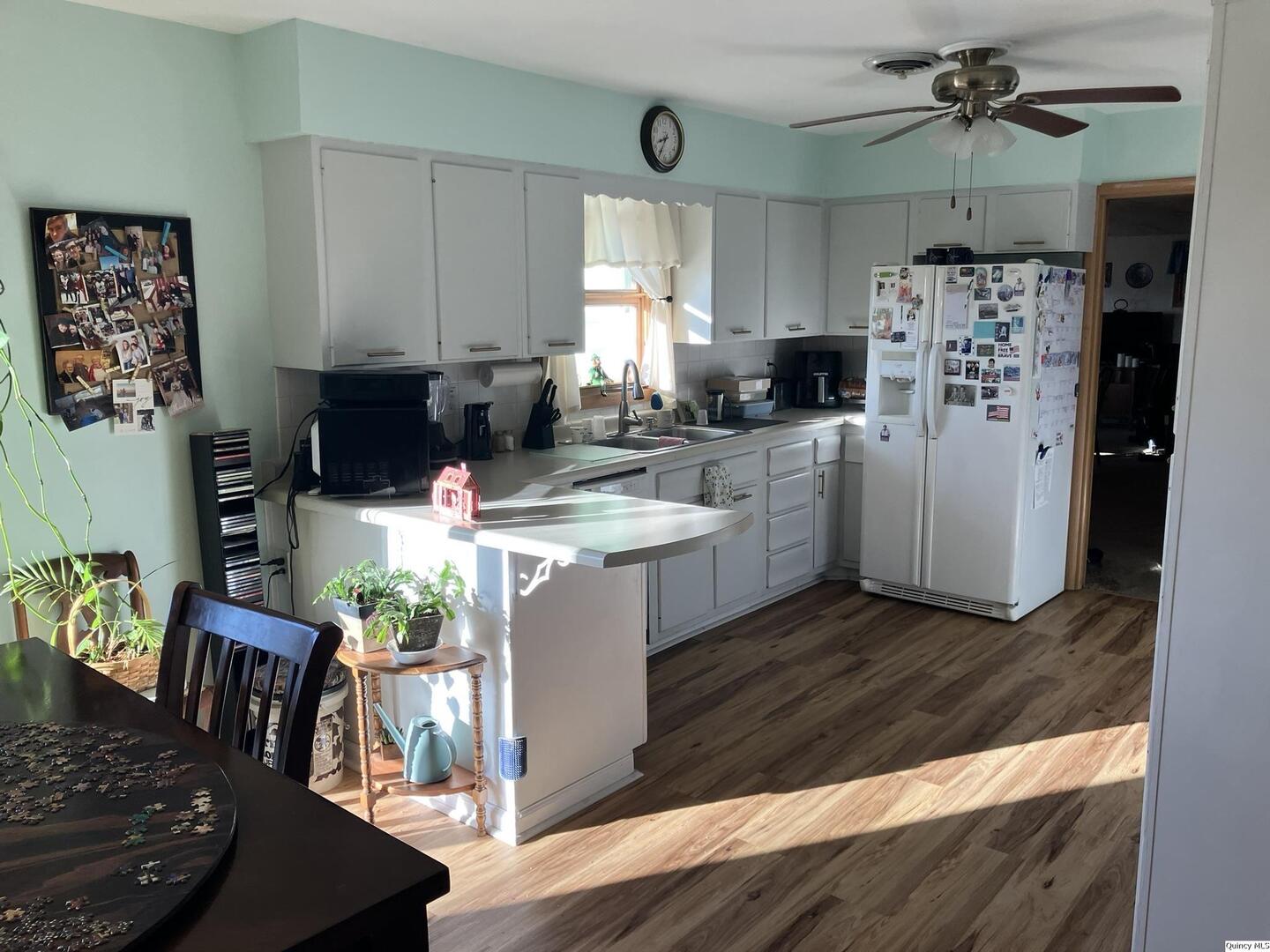 2524 Southbrook Road Quincy, IL 62305 - Photo 4 of 32 a kitchen with stainless steel appliances kitchen island granite countertop a refrigerator a stove a sink dishwasher and a dining table with wooden floor