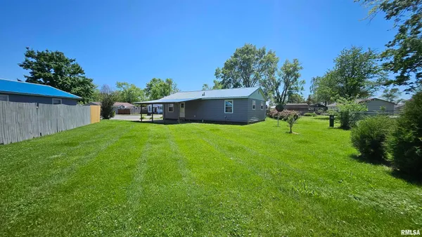 a view of backyard with a barn and large trees