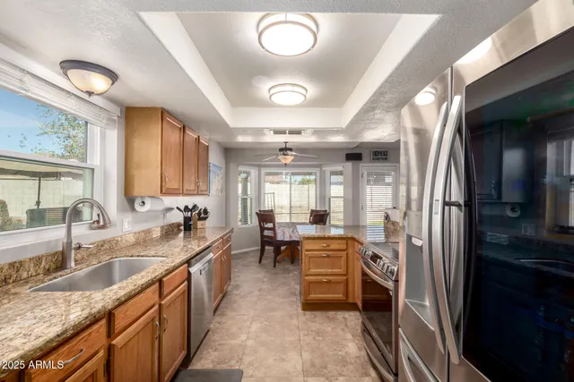 a large kitchen with kitchen island granite countertop a sink and a stove top oven with wooden floor
