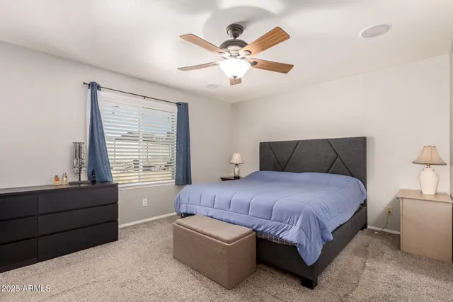 a bedroom with a bed and a flat tv screen on wall
