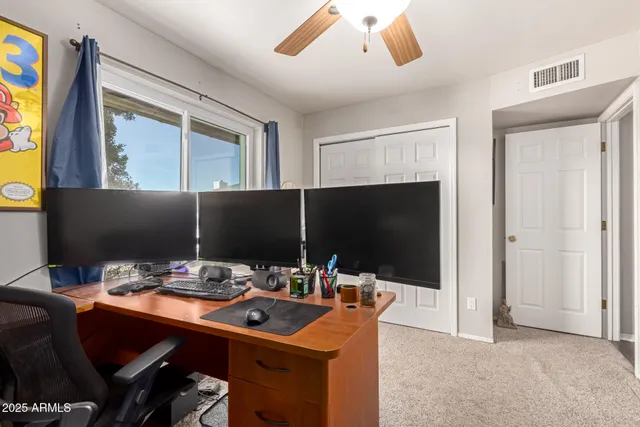 a workspace with furniture and ceiling fan