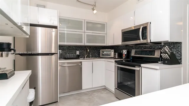 a kitchen with stainless steel appliances granite countertop a refrigerator stove and microwave