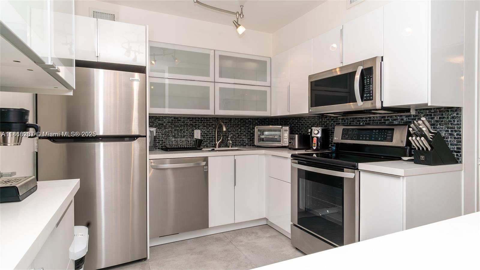 a kitchen with stainless steel appliances granite countertop a refrigerator stove and microwave