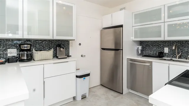 a kitchen with appliances a refrigerator and a sink