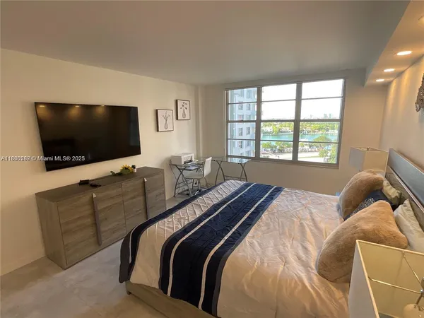 a bedroom with a bed and a flat screen tv